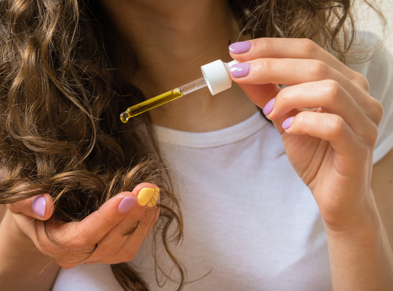 Girl poring hair oil
