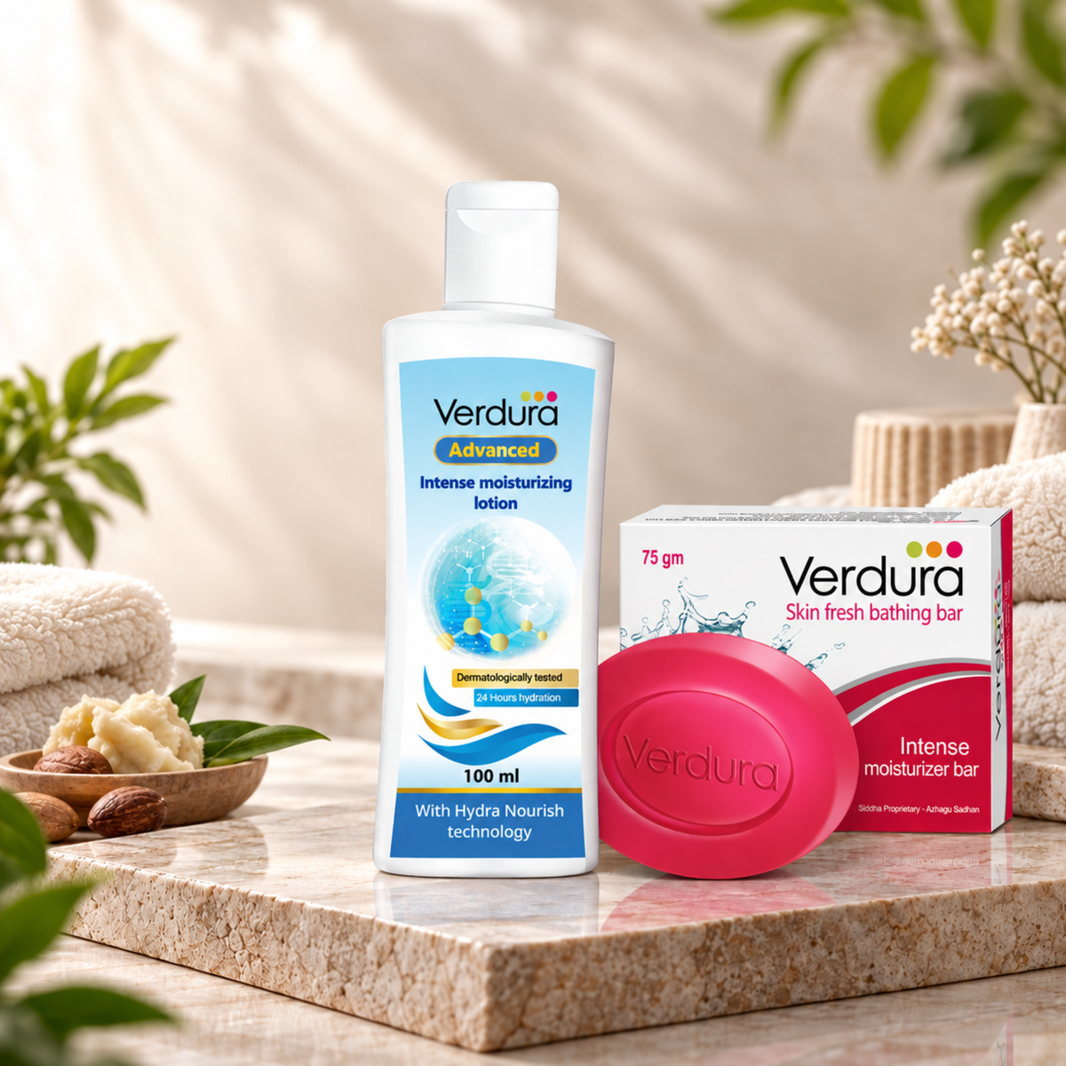 Verdura skincare set featuring a 100 ml bottle of Intense Moisturising Lotion, a 75 gm box of Skin Fresh Bathing Bar, and a pink oval bar of soap, styled on a marble slab with folded towels and botanical elements.