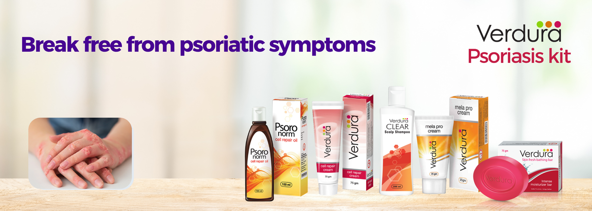 Verdura psoriasis kit products displayed on a light surface with a blurred indoor background. The kit includes several bottles, tubes, boxes, and a pink salve container.